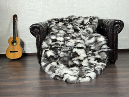 Fox Fur Blanket Throw Black Silver White - Tatifurs draped over a chair, showcasing its luxurious texture and design.