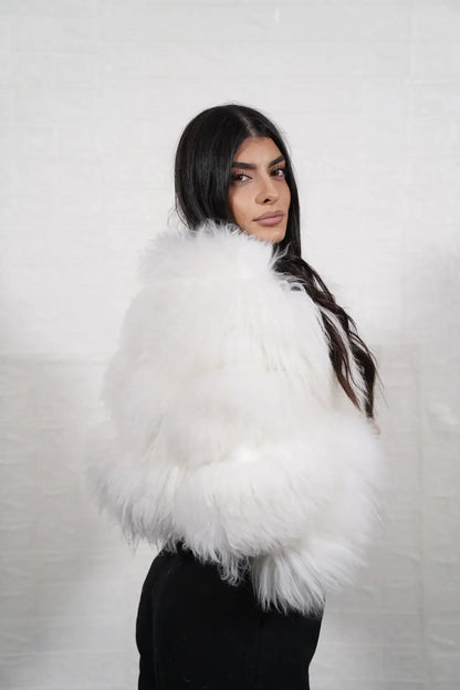 Alpaca fur jacket white shown from the back displaying full cropped bomber silhouette and horizontal leather strip construction across white alpaca rows — Greek craftsmanship, TatiFurs
