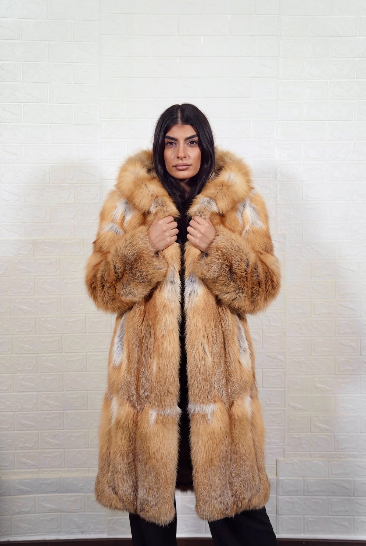 fox fur coat long golden natural front view with both hands on the fur hood worn as a shawl collar showing natural golden fox, warm amber-gold with cream and pale silver highlights fox fur — TatiFurs