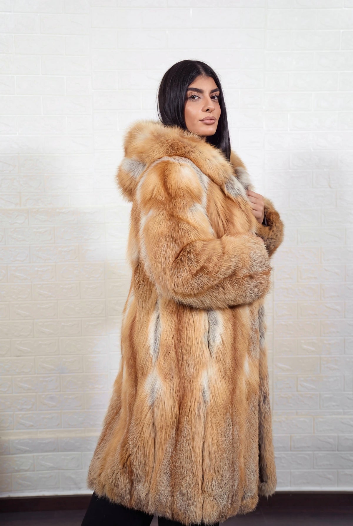 fox fur coat long golden natural side view showing the fur hood, long coat and natural golden fox, warm amber-gold with cream and pale silver highlights fox fur — Greek craftsmanship, TatiFurs
