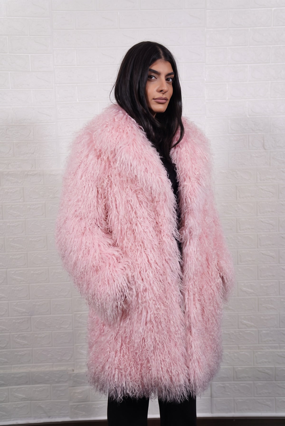 Mongolian coat pink worn with hands in the side pockets showing the open lapel front in soft blush pink Mongolian wool sheepskin — TatiFurs