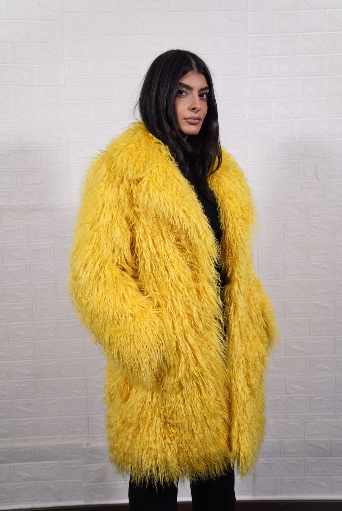 Mongolian coat yellow worn with hands in the side pockets showing the open lapel front in bright sunshine yellow Mongolian wool sheepskin — TatiFurs