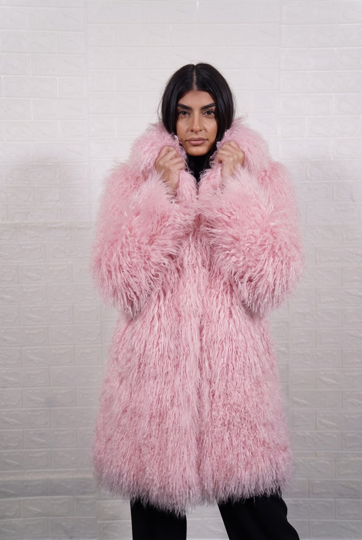 Mongolian coat pink close-up of the lapel collar turned up, showing soft blush pink long curly Mongolian wool pile depth — Greek craftsmanship, TatiFurs