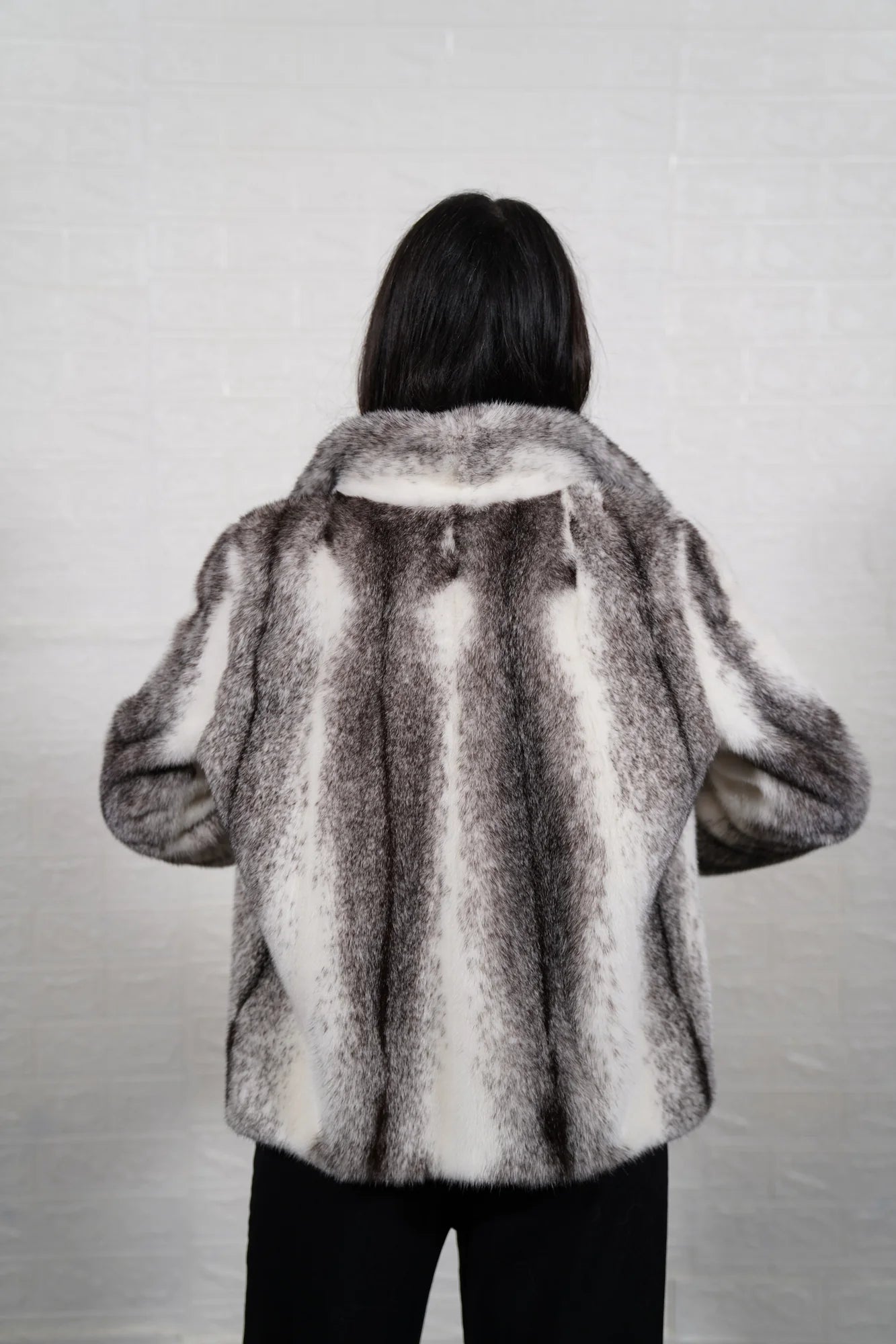 Mink fur jacket cross shown from the side displaying hip level silhouette and natural black white cross cut mink drape — Greek craftsmanship, TatiFurs
