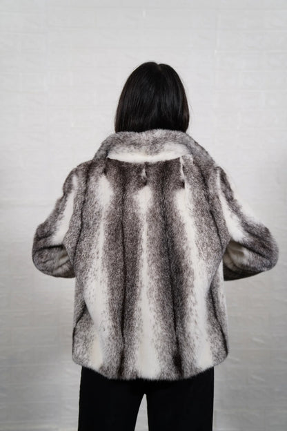 Mink fur jacket cross shown from the side displaying hip level silhouette and natural black white cross cut mink drape — Greek craftsmanship, TatiFurs
