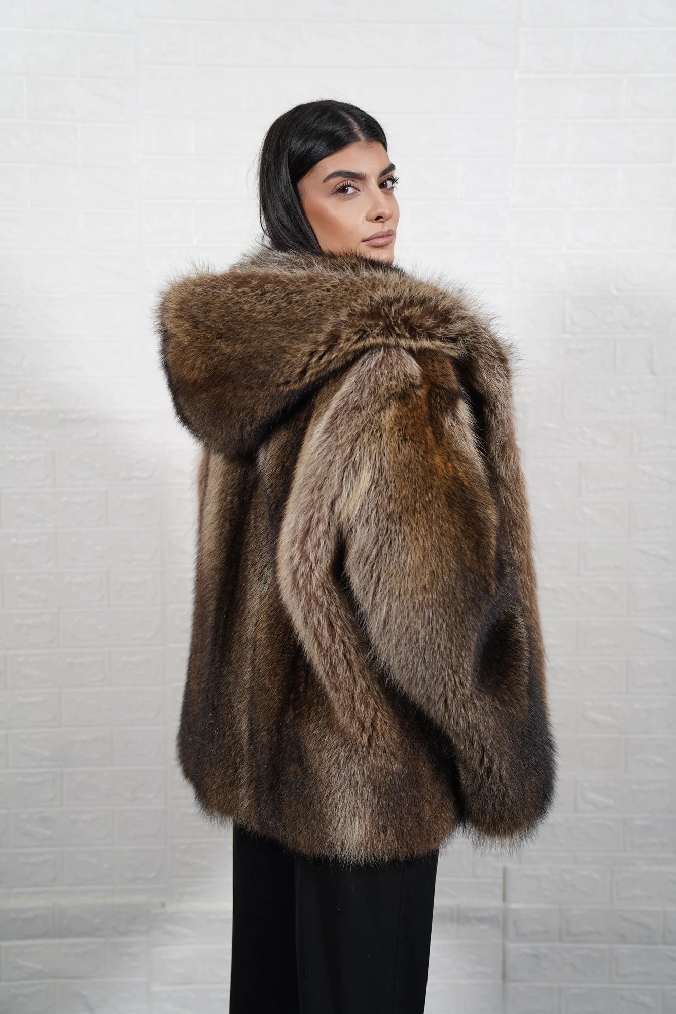 Raccoon fur jacket natural brown hood worn up showing velvet lined hood interior framing face against dramatic natural brown raccoon exterior — Greek craftsmanship, TatiFurs
