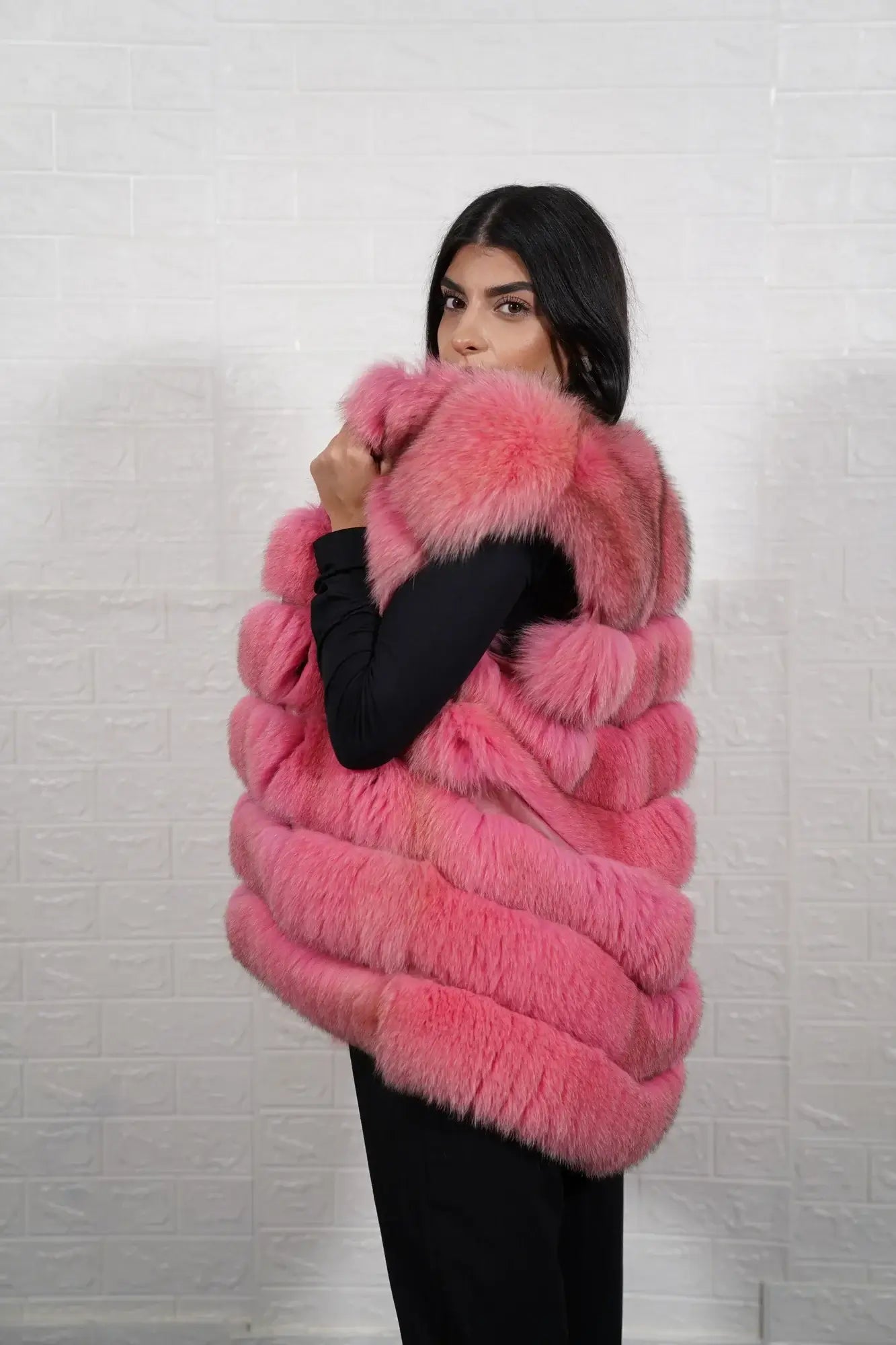 Fox fur vest pink shown from the side displaying hip level silhouette and horizontal leather framed soft pink fox rows — Greek craftsmanship, TatiFurs
