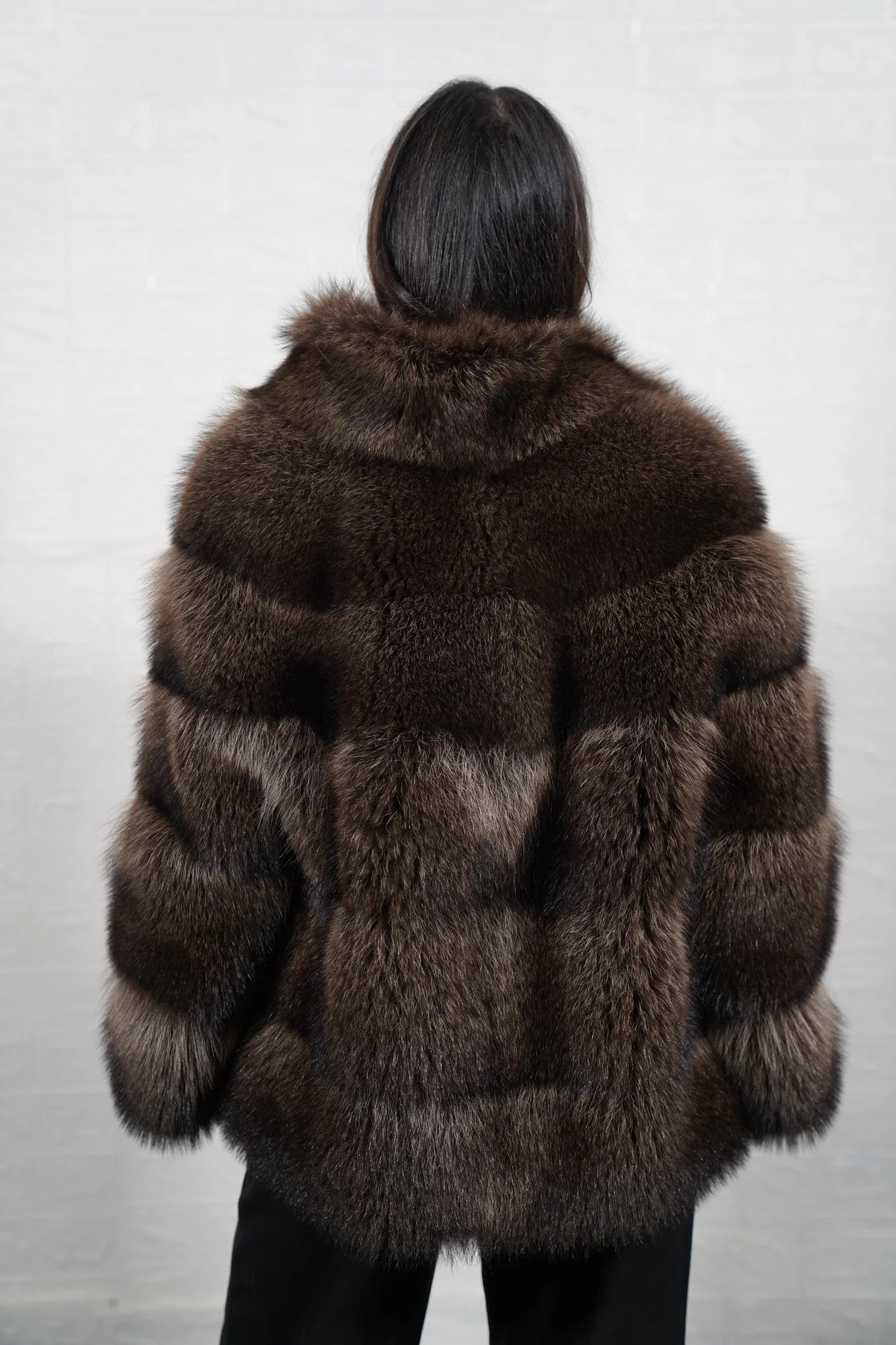 Raccoon fur jacket brown shown from the side displaying below hip silhouette and natural warm brown raccoon pile drape — Greek craftsmanship, TatiFurs
