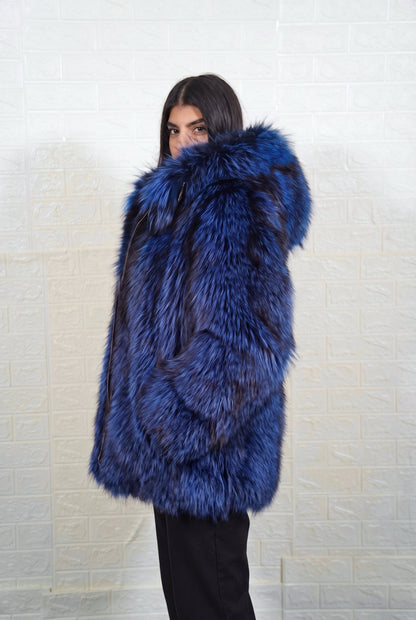 fox fur jacket blue black side profile view, chin tucked in the fur, showing electric blue over jet black fox fur and hip-covering length — Greek craftsmanship, TatiFurs