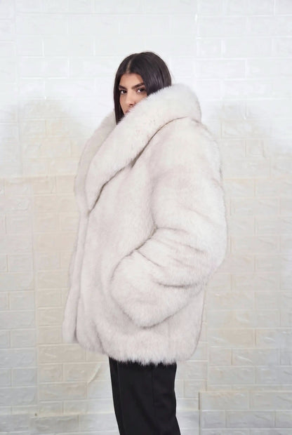 fox fur jacket blue natural side profile view, chin tucked in the fur collar, showing natural blue fox, ivory-white underfur with a soft blue-grey veil at the tips fox fur and hip-covering length — Greek craftsmanship, TatiFurs
