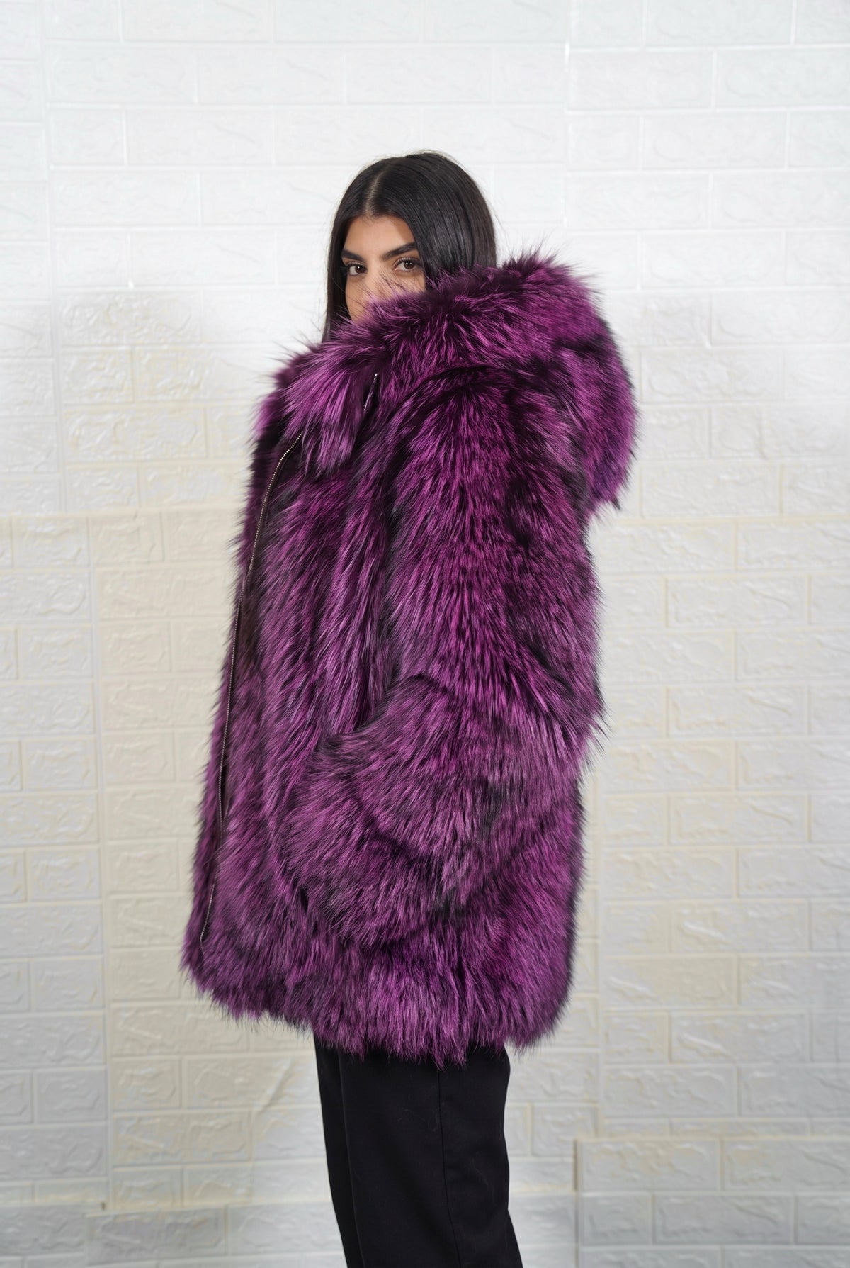 fox fur jacket purple black side profile view, chin tucked in the fur, showing deep violet over jet black fox fur and hip-covering length — Greek craftsmanship, TatiFurs