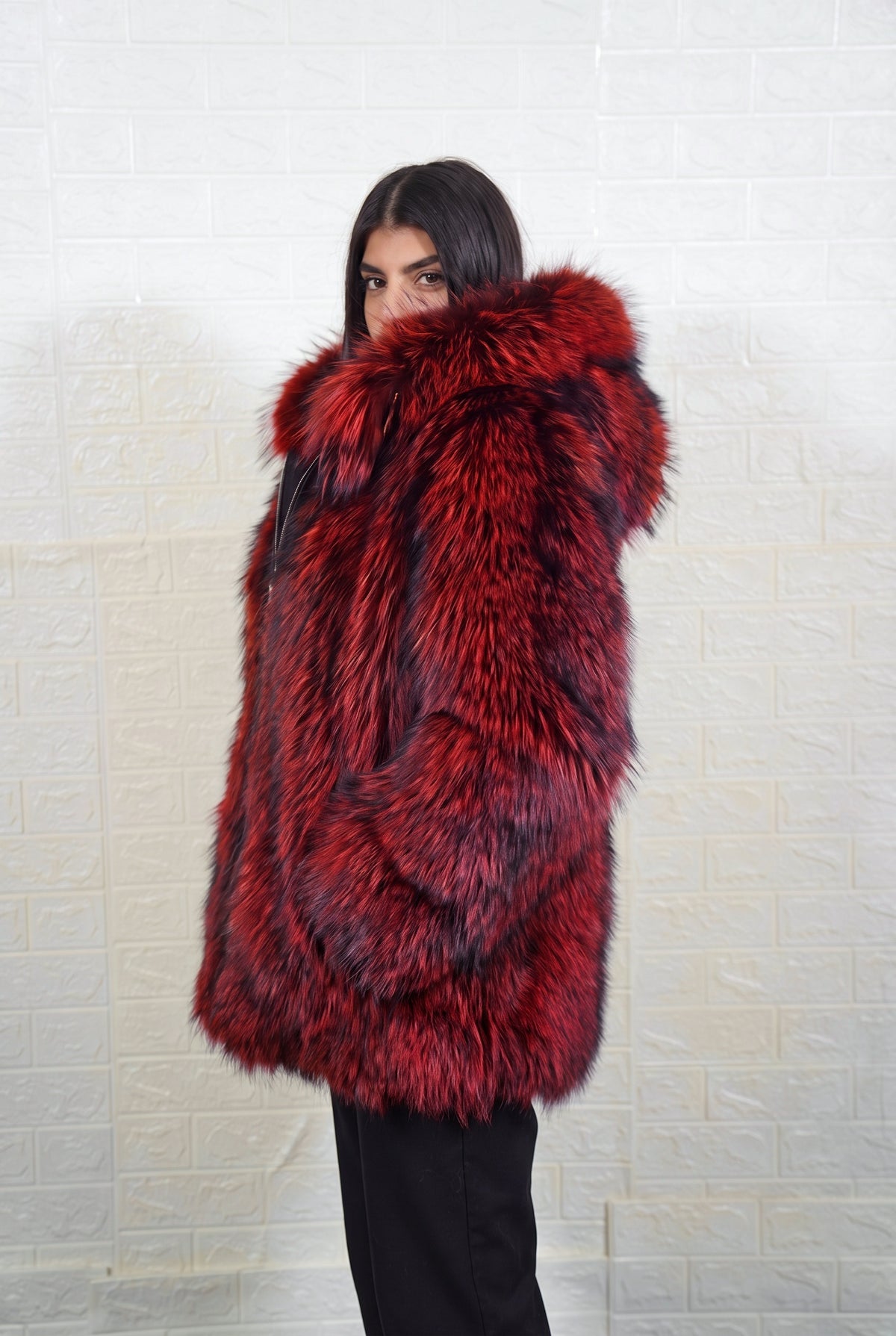 fox fur jacket red black side profile view, chin tucked in the fur, showing deep crimson over jet black fox fur and hip-covering length — Greek craftsmanship, TatiFurs