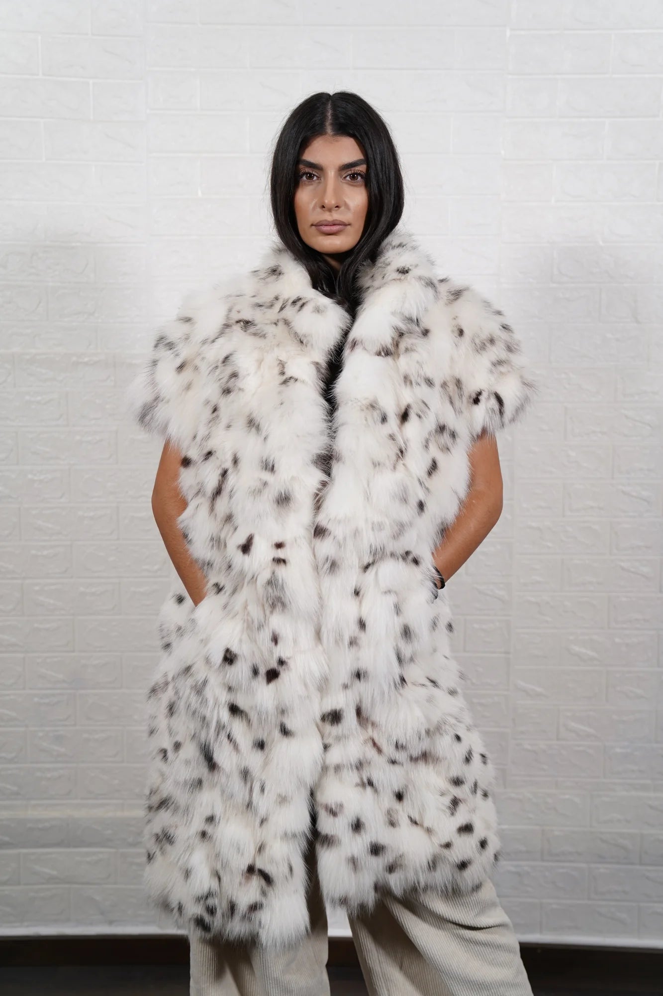 Fox fur vest white dalmatian shown from the side displaying below knee silhouette short sleeves and natural black spotted white fox surface — Greek craftsmanship, TatiFurs
