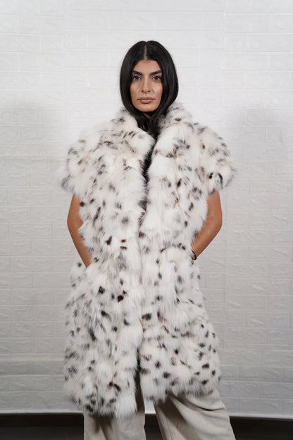 Fox fur vest white dalmatian shown from the side displaying below knee silhouette short sleeves and natural black spotted white fox surface — Greek craftsmanship, TatiFurs
