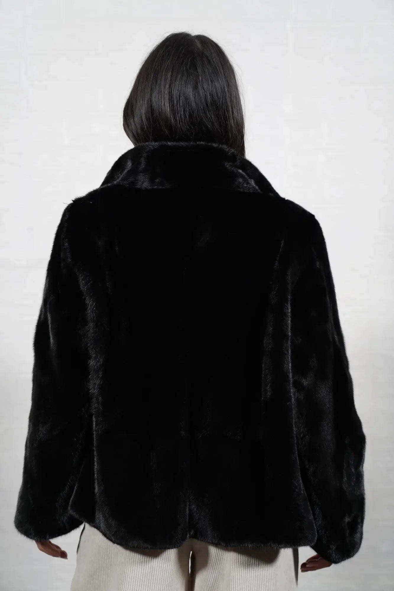 Mink fur jacket black shown from the back displaying full hip level silhouette and consistent flat black solid pattern full skin mink — Greek craftsmanship, TatiFurs
