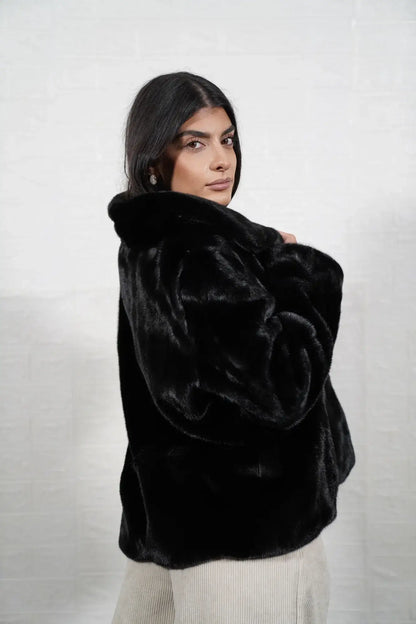 Mink fur jacket black shown from the side displaying hip level silhouette and uniform flat black solid pattern mink surface — Greek craftsmanship, TatiFurs

