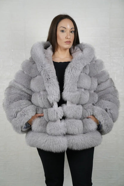 Gray fox fur jacket women shown full length from front displaying hooded silhouette and button closure in horizontal rabbit trimmed gray fox rows — Greek craftsmanship, TatiFurs

