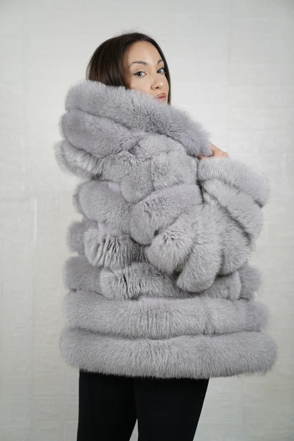 Gray fox fur jacket hood worn up showing velvet lined hood interior framing face against cool atmospheric gray fox rabbit trim exterior — Greek craftsmanship, TatiFurs
