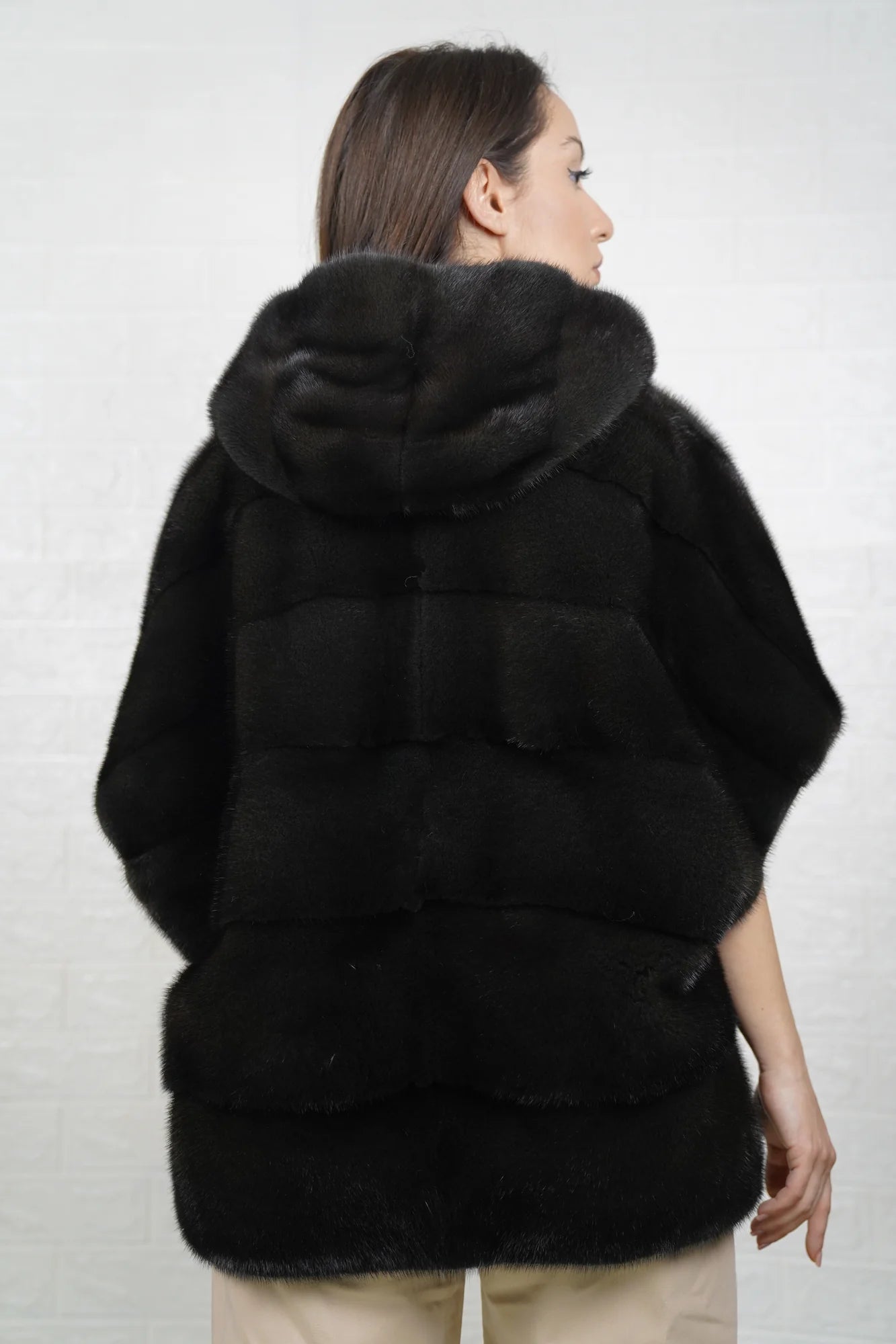 Mink fur cape dark green shown from the back displaying sleeveless silhouette and fluid skin on skin dark green mink drape
