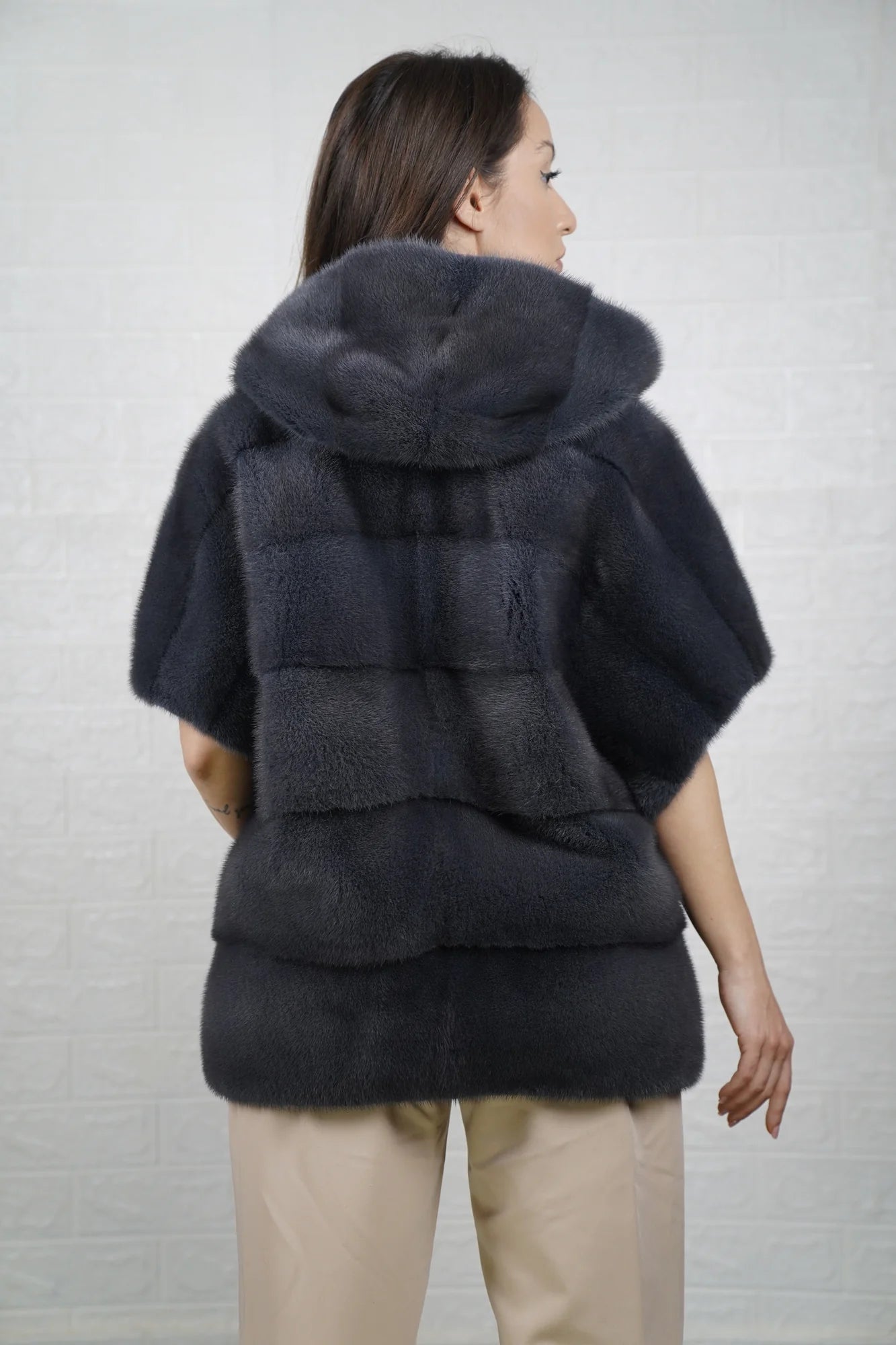 Mink fur cape gray shown from the back displaying hooded short sleeved silhouette and fluid skin on skin cool gray mink drape
