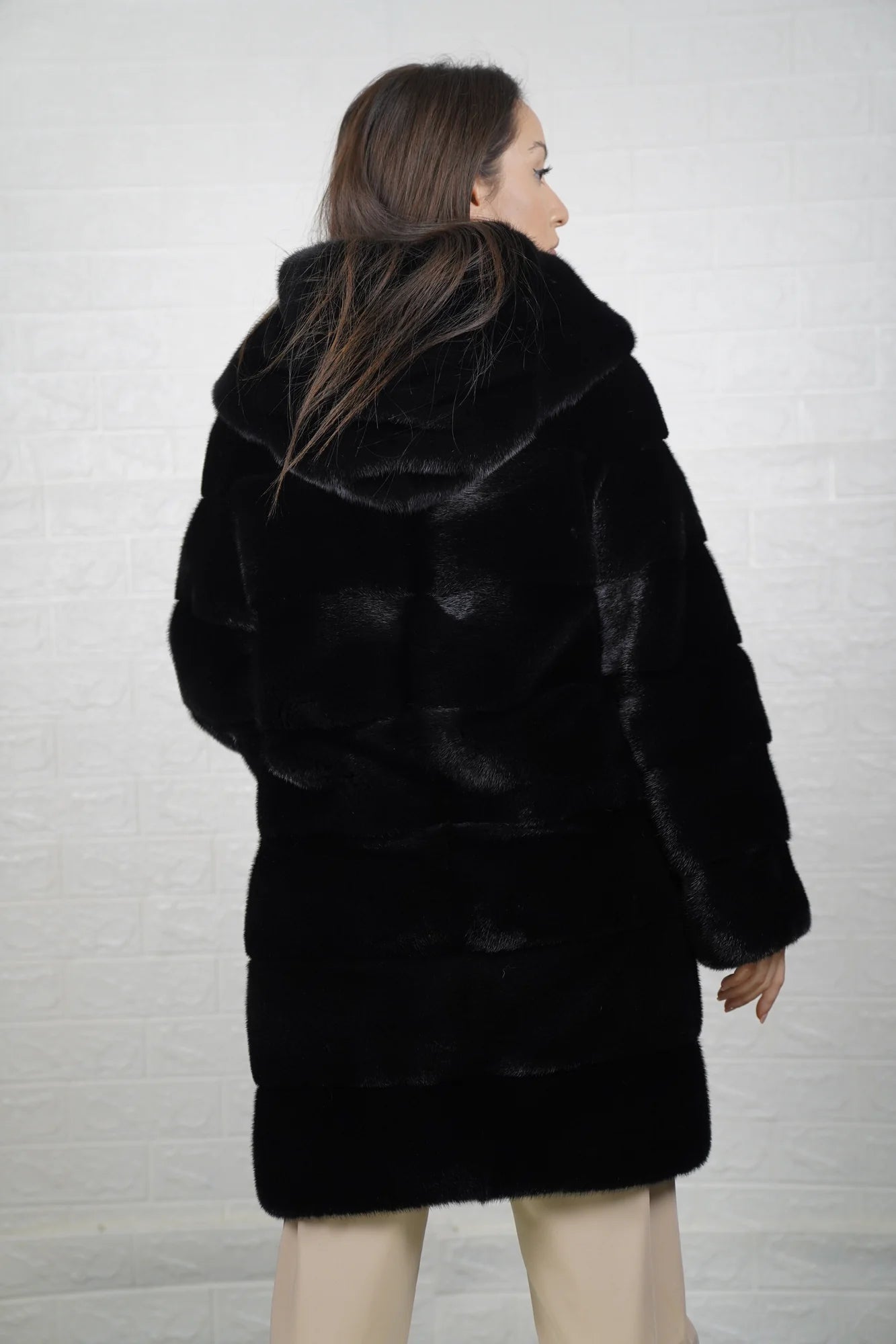 Mink fur coat black with hood shown from the back displaying full above the knee silhouette and deep consistent black skin on skin mink flow — Greek craftsmanship, TatiFurs
