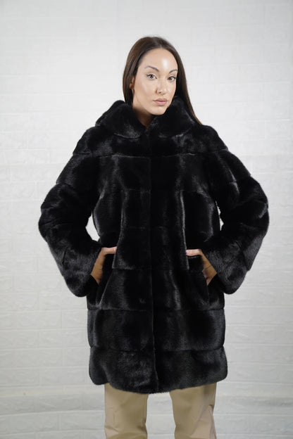 Mink fur coat black with hood shown from the back displaying full above the knee silhouette and deep consistent black skin on skin mink flow — Greek craftsmanship, TatiFurs
