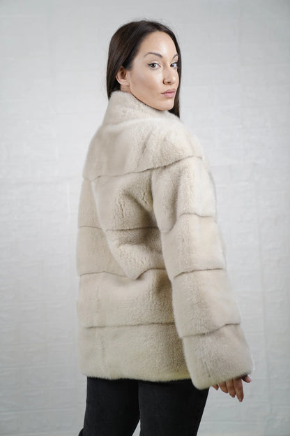 Mink fur jacket light beige close-up texture showing skin on skin vertical pelt flow and warm luminous light beige mink depth
