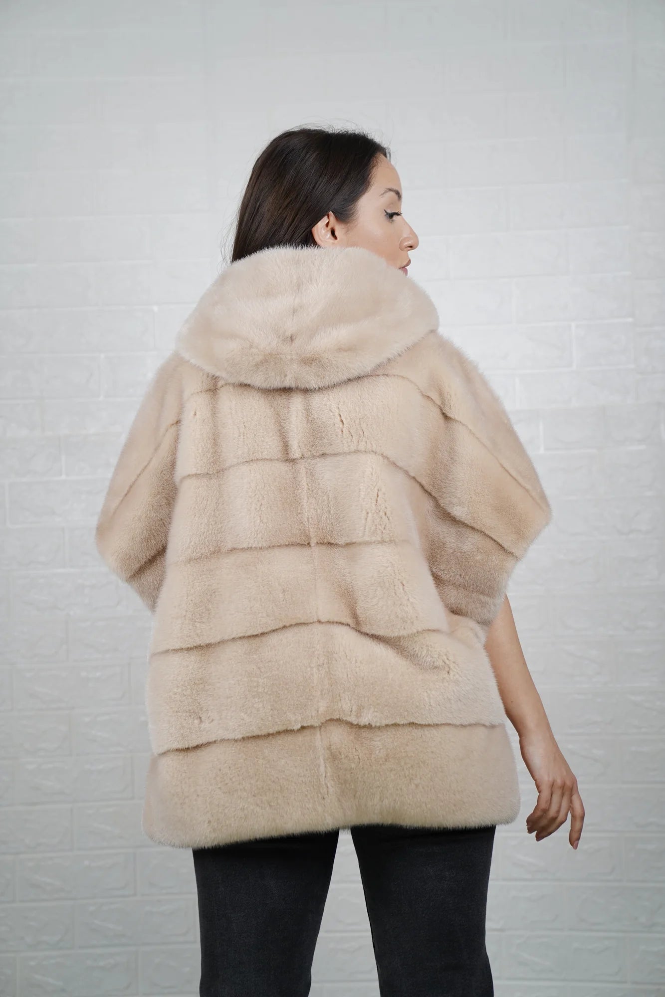 Mink fur cape beige shown from the back displaying hooded short sleeved silhouette and fluid skin on skin beige mink drape
