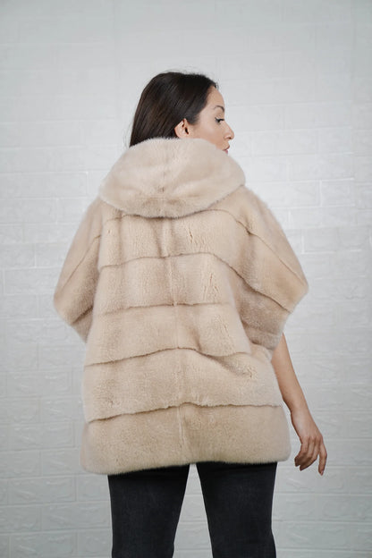 Mink fur cape beige shown from the back displaying hooded short sleeved silhouette and fluid skin on skin beige mink drape
