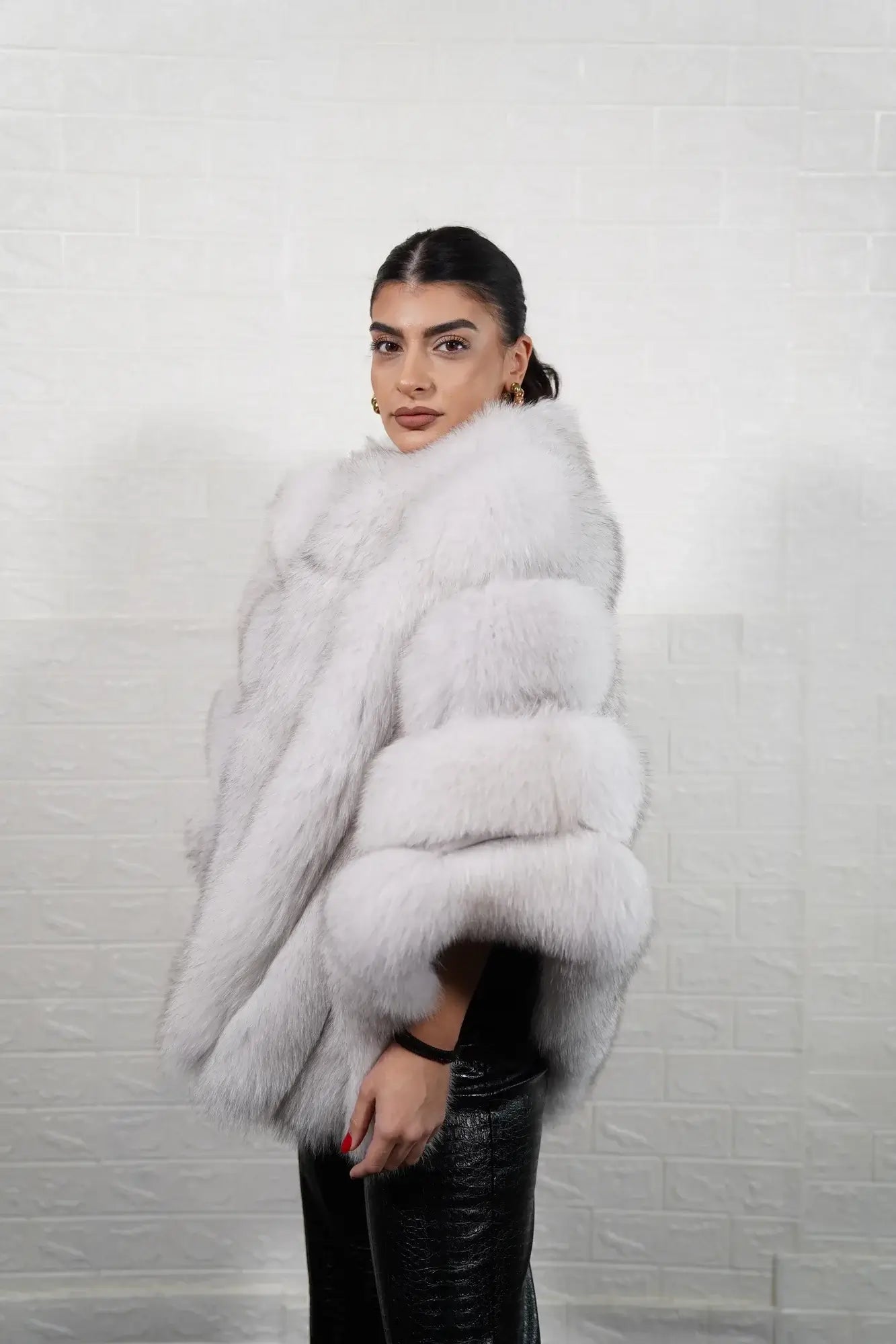 Fox fur poncho blue natural shown from the side displaying hip level poncho silhouette and luminous natural blue fox horizontal rows with rabbit trim — Greek craftsmanship, TatiFurs
