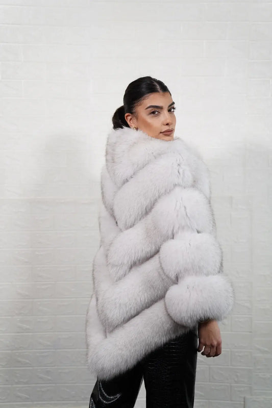 Fox fur poncho blue natural displaying full skin natural blue fox horizontal rows with rabbit fur trim strips and hip level poncho silhouette — Greek craftsmanship, TatiFurs
