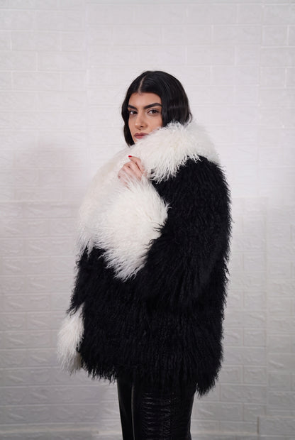 Mongolian jacket black and white shown from the side displaying hip level silhouette and jet black with ivory white long curly Mongolian wool — Greek craftsmanship, TatiFurs
