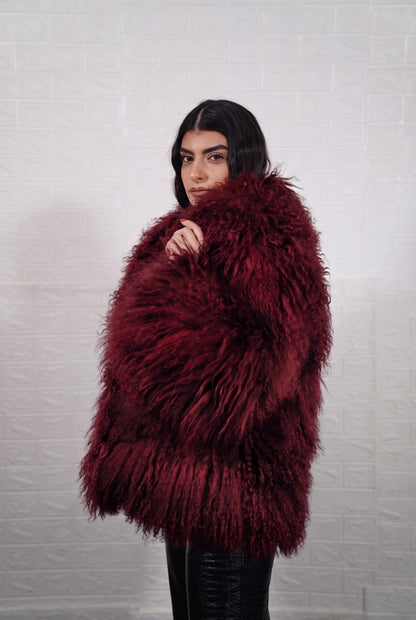 Mongolian jacket burgundy shown from the side displaying hip level silhouette and deep wine burgundy long curly Mongolian wool — Greek craftsmanship, TatiFurs