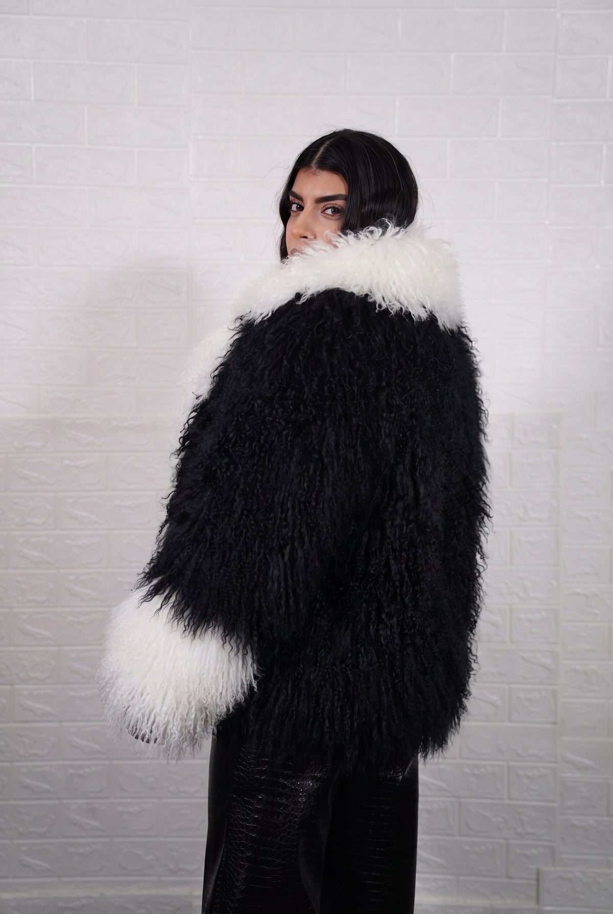 Mongolian jacket black and white shown from the back displaying full hip level silhouette and consistent jet black with ivory white curly wool surface — Greek craftsmanship, TatiFurs