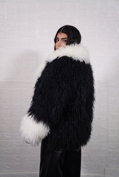 Mongolian jacket black and white shown from the back displaying full hip level silhouette and consistent jet black with ivory white curly wool surface — Greek craftsmanship, TatiFurs