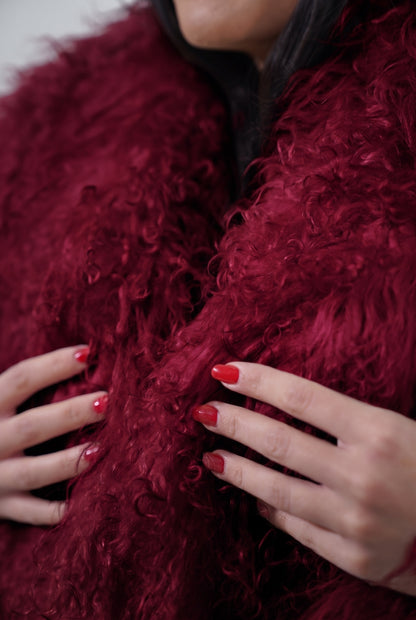 Mongolian jacket burgundy close-up texture showing deep wine burgundy long curly Mongolian wool pile depth — Greek craftsmanship, TatiFurs