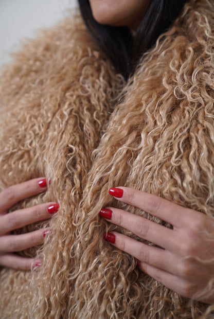 Mongolian jacket light brown close-up texture showing warm honey light brown long curly Mongolian wool pile depth — Greek craftsmanship, TatiFurs
