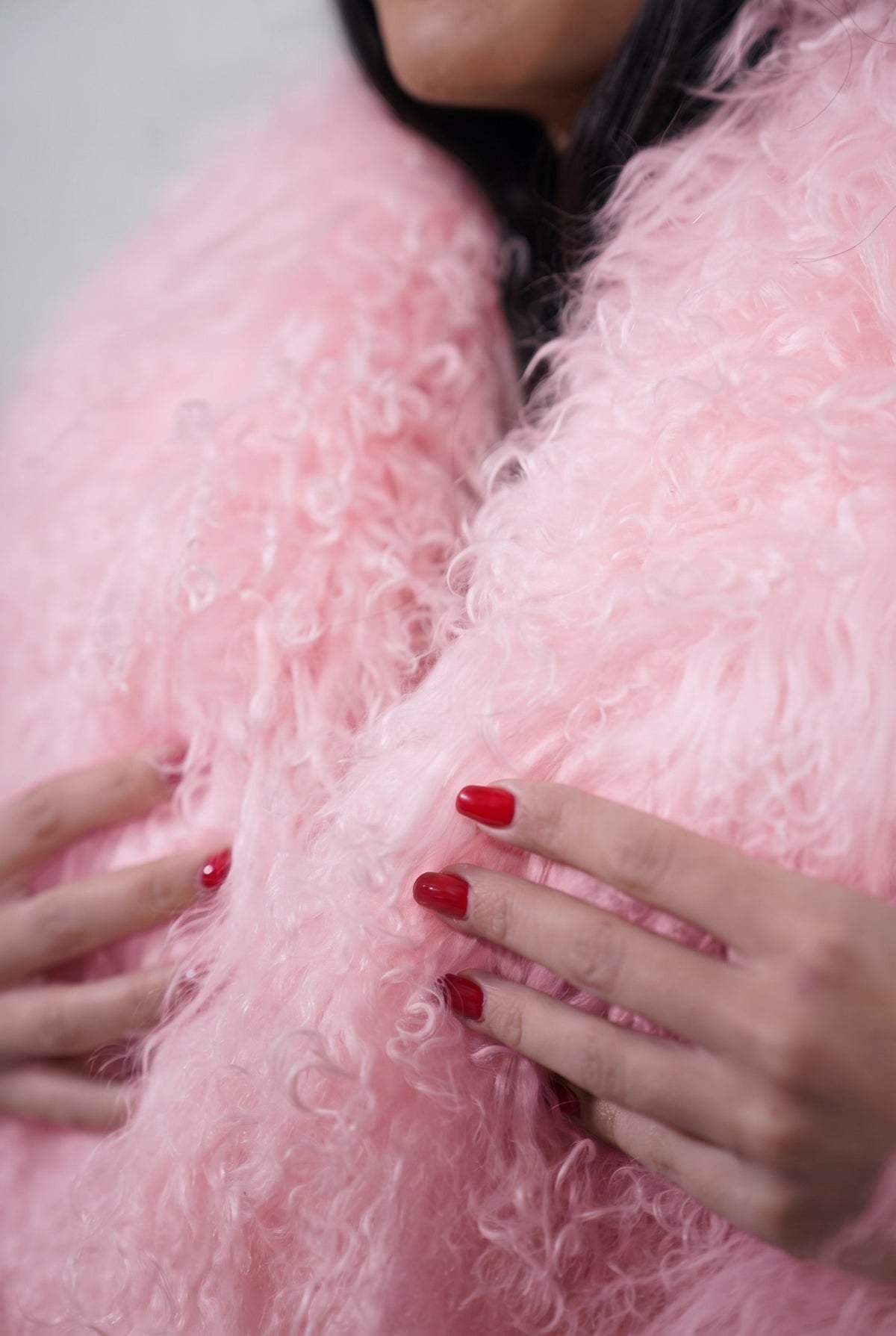 Mongolian jacket pink close-up texture showing soft blush pink long curly Mongolian wool pile depth — Greek craftsmanship, TatiFurs