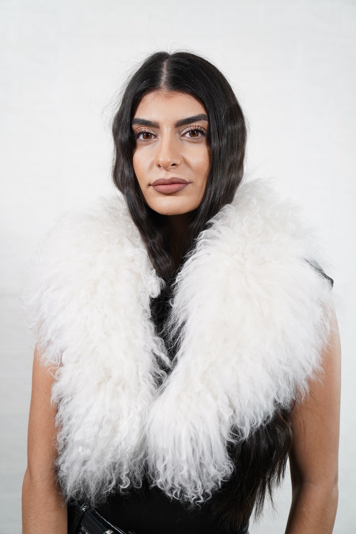 Mongolian Sheepskin Collar White — Curly Lamb Fur worn by a woman, front view of the long curly pure snow white Tibetan lamb fur framing the face and shoulders, TatiFurs