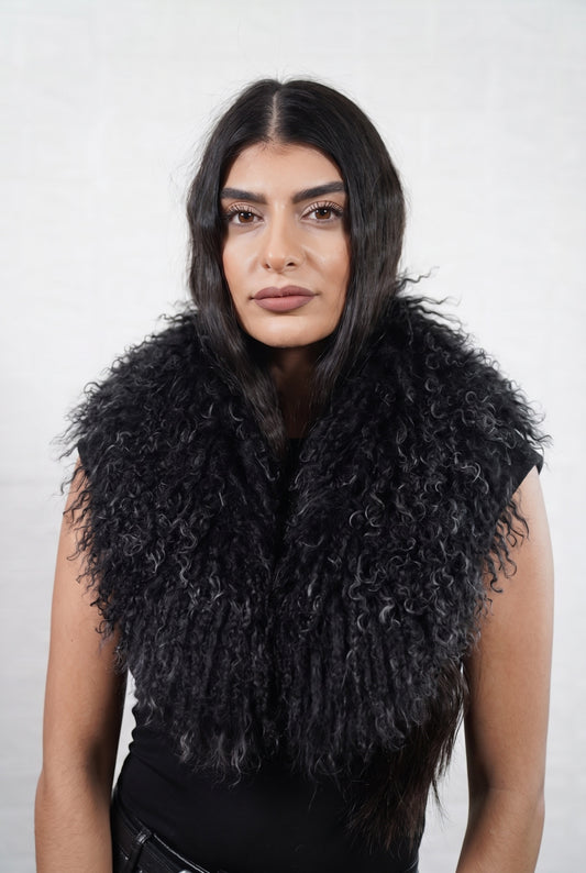 Mongolian Sheepskin Collar Black — Curly Lamb Fur worn by a woman, front view of the long curly deep jet black Tibetan lamb fur framing the face and shoulders, TatiFurs