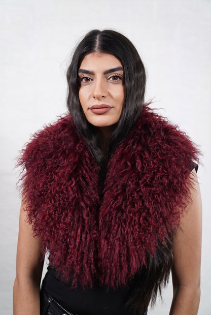 Mongolian Sheepskin Collar Burgundy — Curly Lamb Fur worn by a woman, front view of the long curly deep oxblood burgundy Tibetan lamb fur framing the face and shoulders, TatiFurs