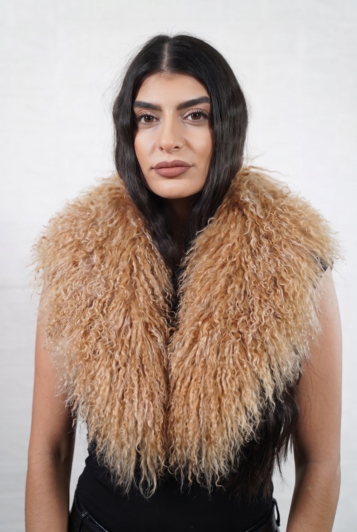 Mongolian Sheepskin Collar Camel — Curly Lamb Fur worn by a woman, front view of the long curly warm natural camel Tibetan lamb fur framing the face and shoulders, TatiFurs