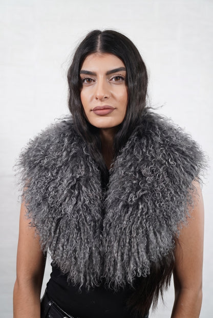 Mongolian Sheepskin Collar Grey — Curly Lamb Fur worn by a woman, front view of the long curly smoky charcoal grey Tibetan lamb fur framing the face and shoulders, TatiFurs