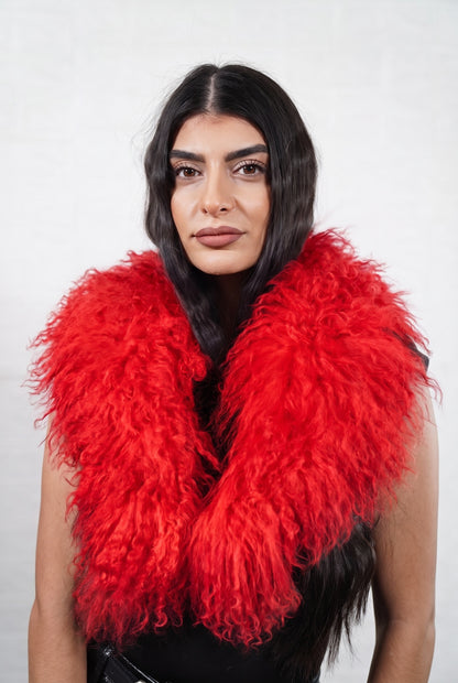 Mongolian Sheepskin Collar Red — Curly Lamb Fur worn by a woman, front view of the long curly vivid scarlet red Tibetan lamb fur framing the face and shoulders, TatiFurs