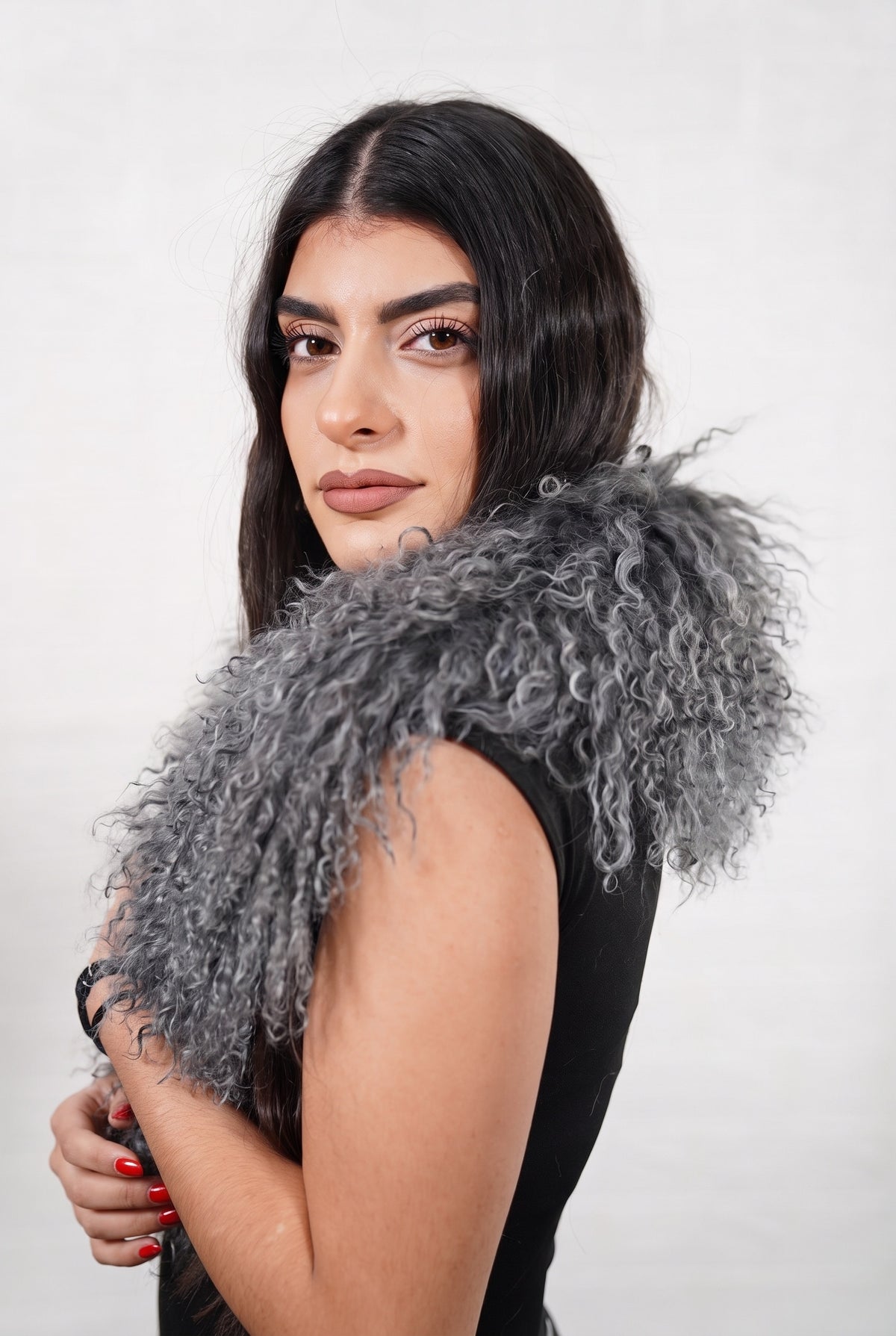 Mongolian Sheepskin Collar Grey — Curly Lamb Fur three-quarter view over the shoulder, volume of the smoky charcoal grey Mongolian lamb curls around the neck — handmade in Greece, TatiFurs