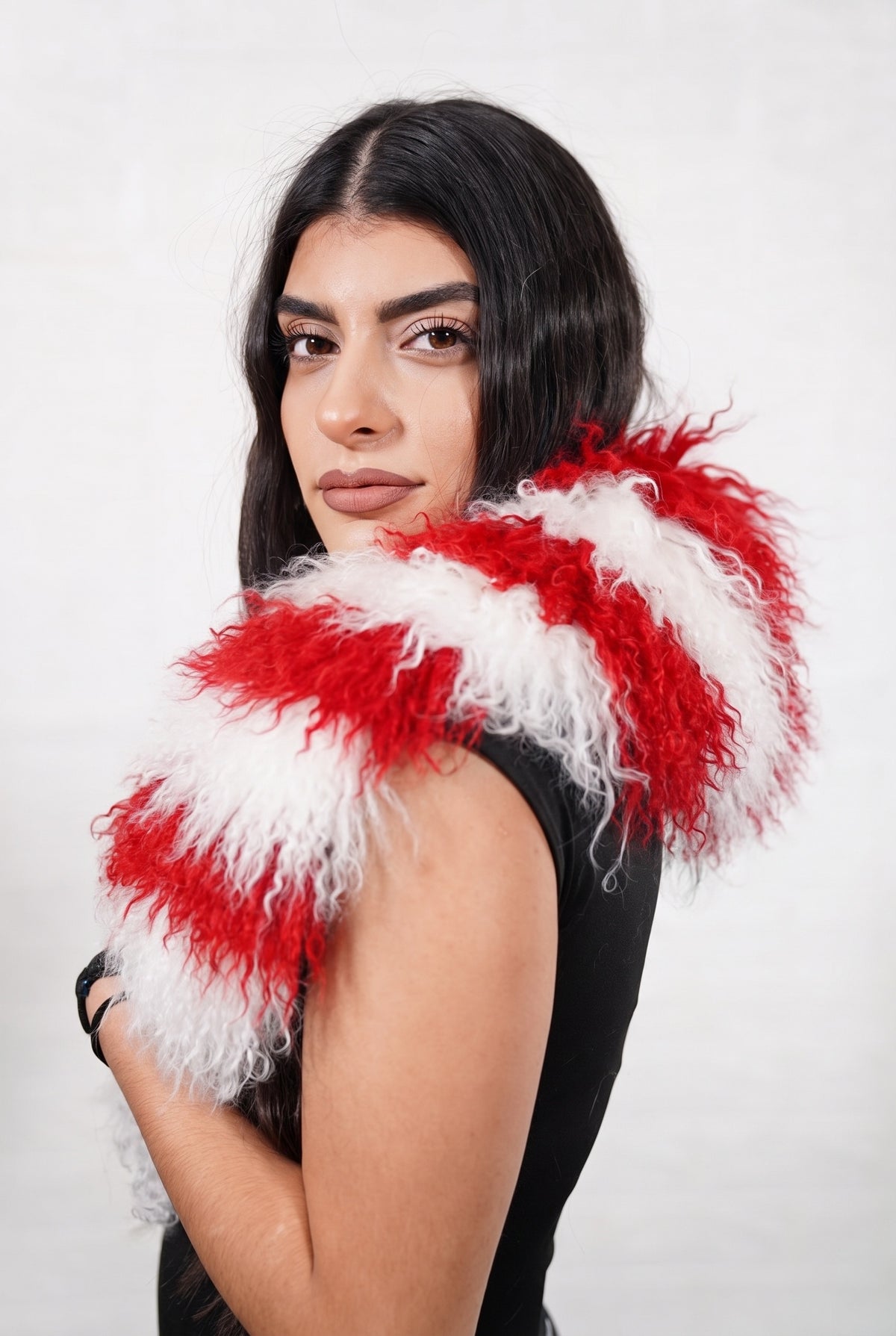 Mongolian Sheepskin Collar Red White — Curly Lamb Fur, Xmas Edition three-quarter view over the shoulder, volume of the candy-cane red and white striped Mongolian lamb curls around the neck — handmade in Greece, TatiFurs