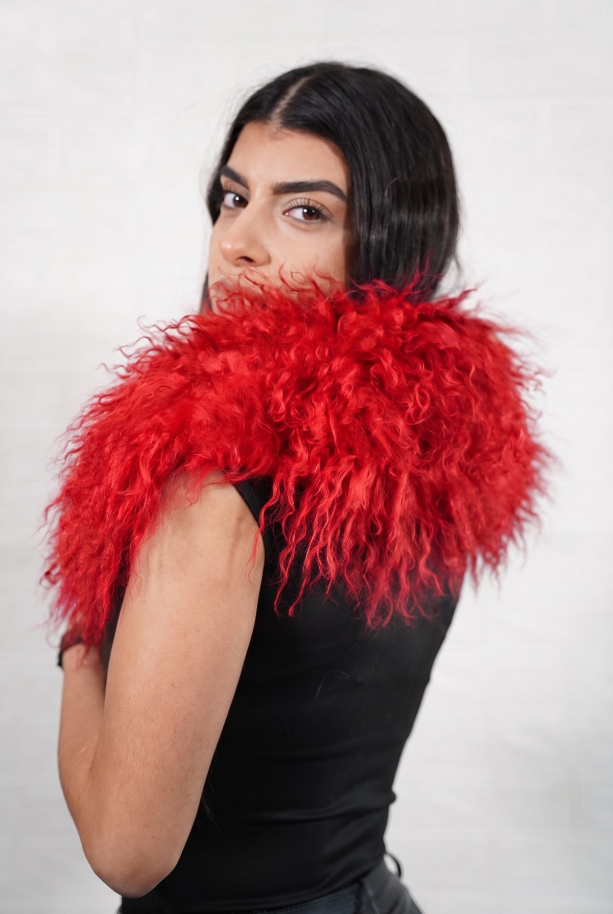Mongolian Sheepskin Collar Red — Curly Lamb Fur seen from behind, vivid scarlet red curly sheepskin wrapped high around the neck and shoulders — TatiFurs