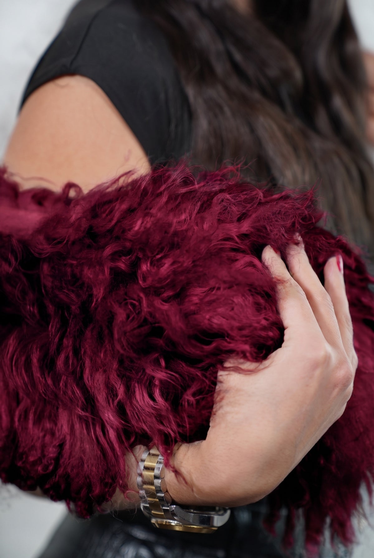 Mongolian Sheepskin Collar Burgundy — Curly Lamb Fur close-up of the dense deep oxblood burgundy Tibetan lamb curls held in the hand — TatiFurs