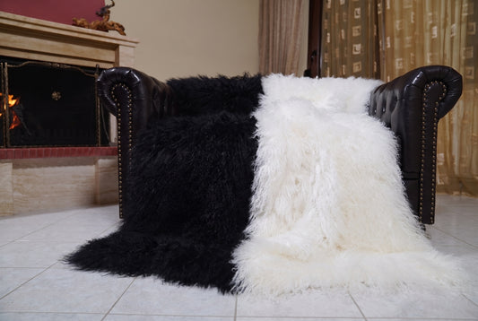 Mongolian Blanket Throw Black White Two Tone — Wool Sheepskin spread across the leather sofa showing the whole jet black and pure white Mongolian wool surface — Greek craftsmanship, TatiFurs