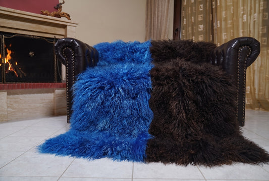 Mongolian Blanket Throw Blue Dark Brown Two Tone — Wool Sheepskin spread across the leather sofa showing the whole cobalt blue and espresso brown Mongolian wool surface — Greek craftsmanship, TatiFurs